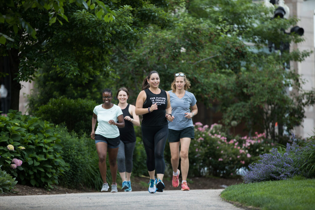 three women running down a path in the park