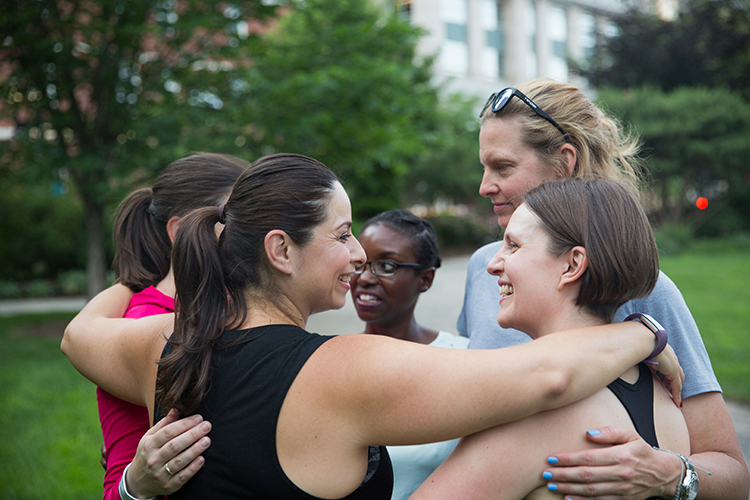 a group of women hugging each other outside