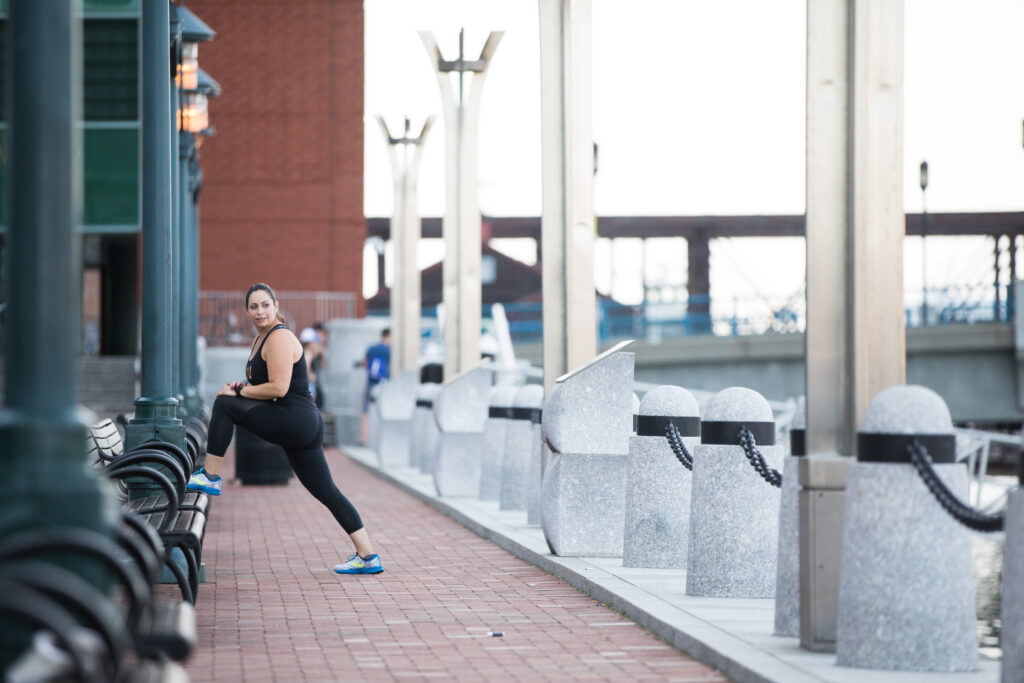 a woman stretching on a bench in the city