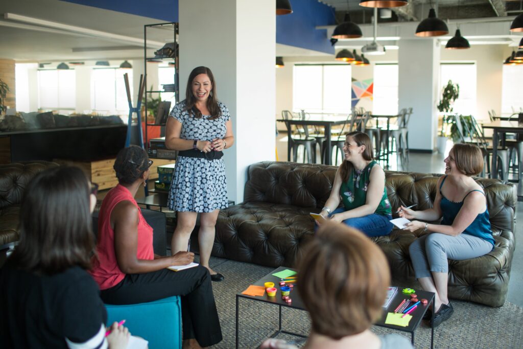 a group of women sitting around a living room together