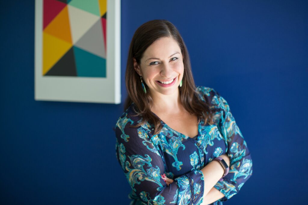 a woman standing in front of a blue wall