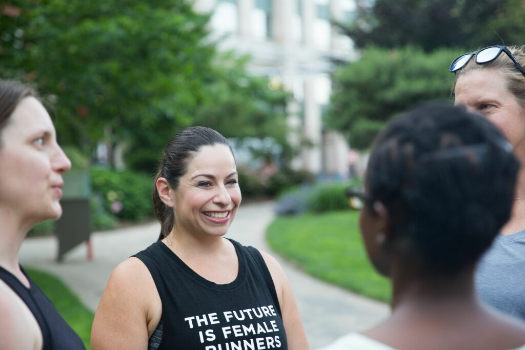 a woman in a black shirt is talking to another woman