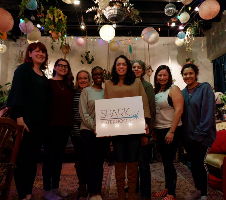 a group of women standing next to each other holding a sign