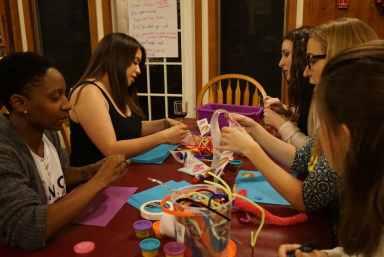 a group of women sitting around a table together