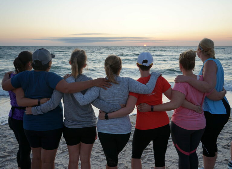 a group of people standing on top of a beach